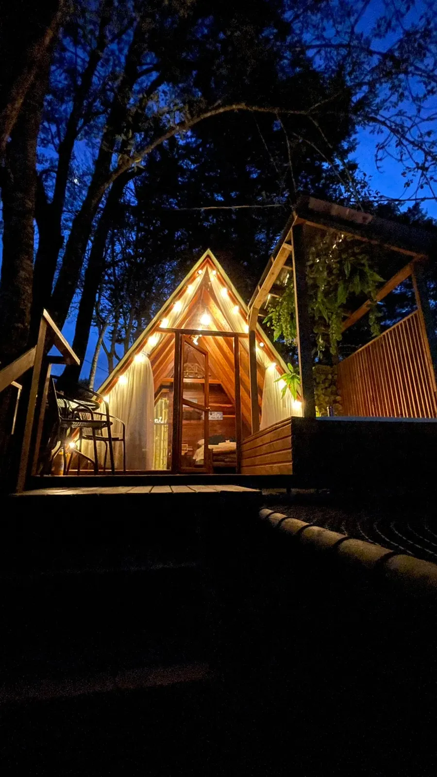 Cabaña Menta iluminada en la noche con su terraza