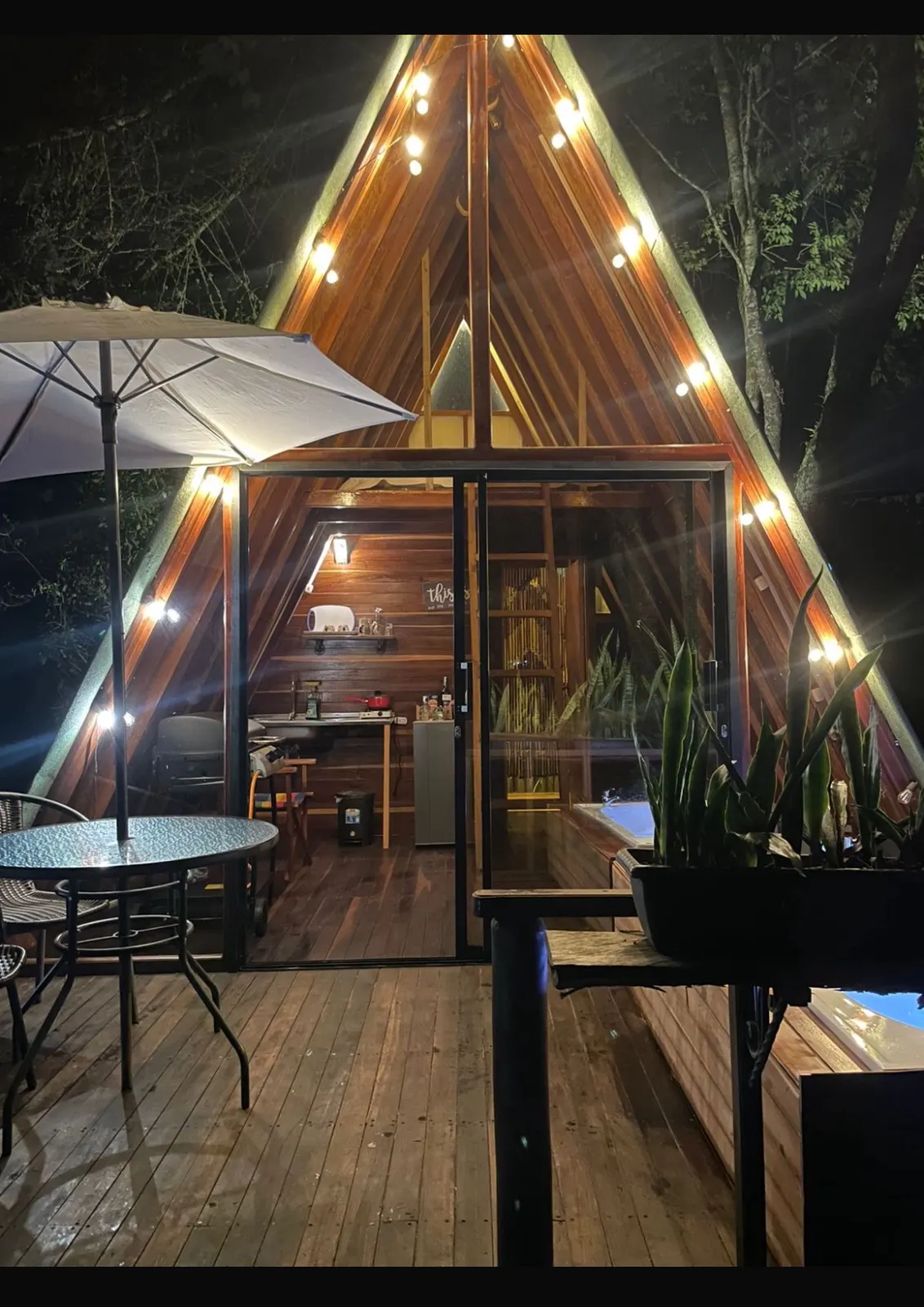 Terraza de la cabaña Eucalipto con sombrilla y luces