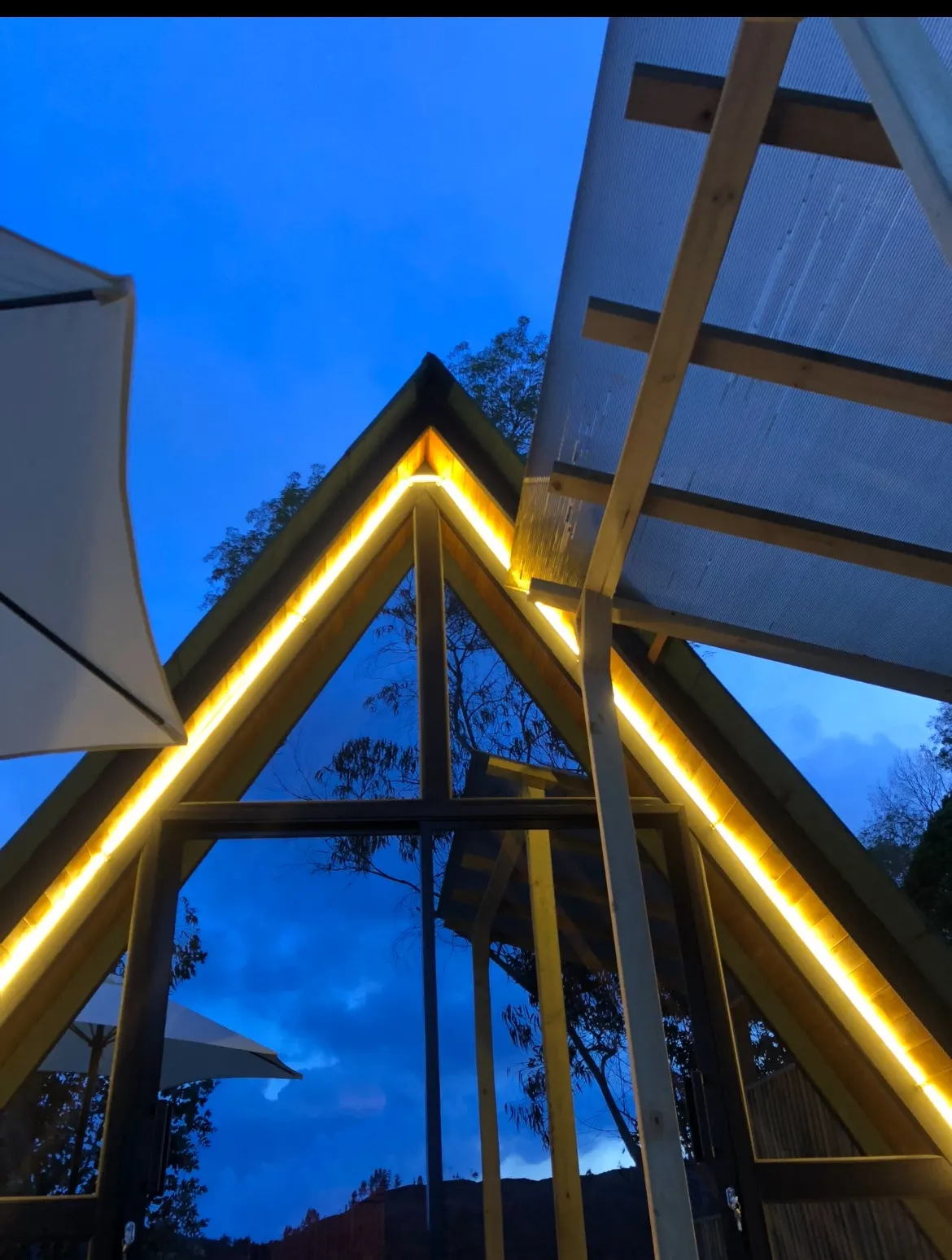 Fachada de la cabaña Benjamín en forma de A con luces cálidas