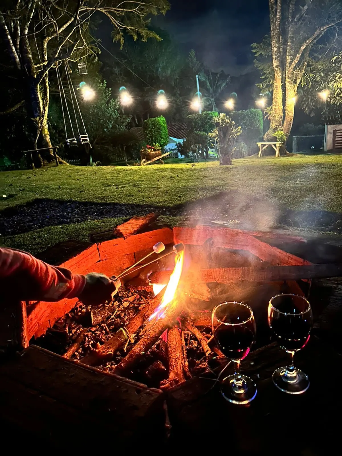 Fogata encendida con dos copas de vino en Belive Glamping