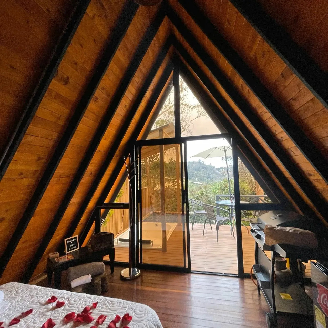 Interior de la cabaña Benjamín con vigas de madera y puerta a la terraza